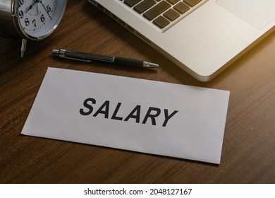 Salary or bonus money in paper envelope at workplace in office.salary text written on paper envelope.Close up concept. - Shutterstock ID 2048127167