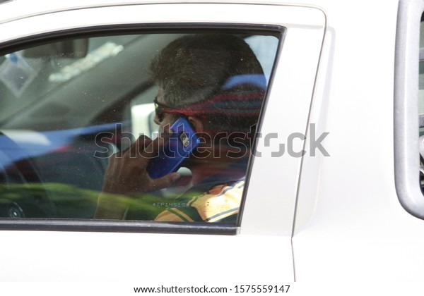 SALAVDOR, BAHIA / BRAZIL - October 21, 2016: Driver is\
seen using the mobile device while driving in the city of Salvador\
(BA). 