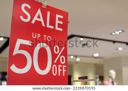 Sale up to 50% off text on a display board stand inside a popular clothing store during year end season sale