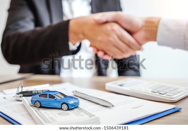 Sale agent handshake deal to agreement\
successful car loan contract with customer and sign agreement\
contract  Insurance car\
concept.