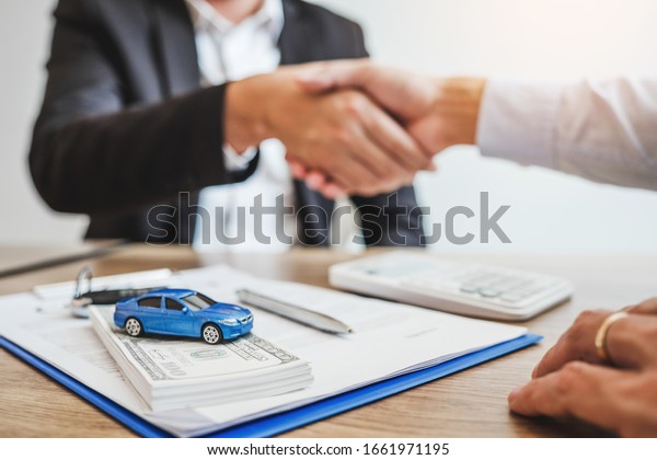 Sale agent handshake deal to agreement\
successful car loan contract with customer and sign agreement\
contract Insurance car\
concept.