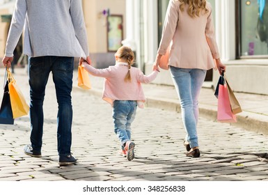 Sale, Consumerism And People Concept - Close Up Of Happy Family With Little Child And Shopping Bags In City