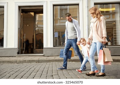 Sale, Consumerism And People Concept - Happy Family With Little Child And Shopping Bags In City