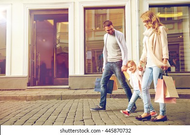 Sale, Consumerism And People Concept - Happy Family With Little Child And Shopping Bags In City