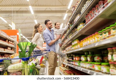 sale, consumerism and people concept - happy family with child and shopping cart buying food at grocery store or supermarket - Powered by Shutterstock