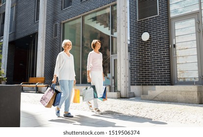 Sale, Consumerism And People Concept - Two Senior Women Or Friends With Shopping Bags Walking Along Tallinn City Street