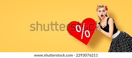 Sale discounts offer concept - woman hold heart shape % percentage gesign. Pinup girl show red signboard. Rockabilly model rebates ad. Isolated yellow background. Valentine or like symbol. Wide banner