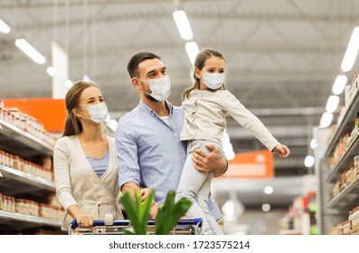 Sale, Family And Pandemic Concept - Happy Mother, Father And Little Daughter Wearing Face Protective Medical Masks For Protection From Virus Disease With Shopping Cart Buying Food At Supermarket