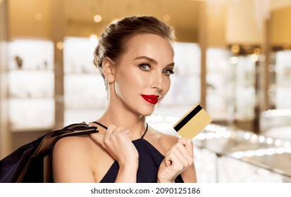 Sale, Luxury And People Concept - Smiling Woman In Dress With Shopping Bags And Credit Card Over Jewelry Store Background