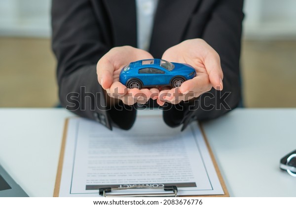 Sale man agent present a car in showroom sale\
car and Insurance car\
concept.