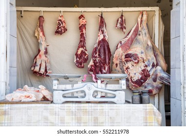 The sale of meat from the open counter with the old weighing scale. Focus on the carcasses of meat. - Powered by Shutterstock