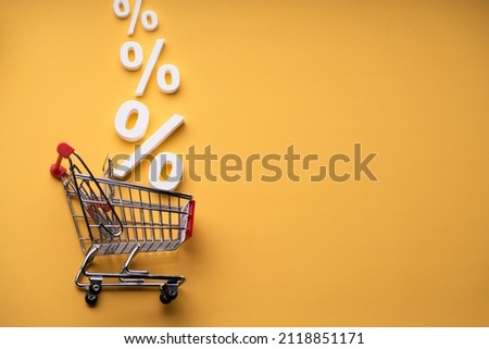 Sale Percents Falling Into Shopping Cart On Yellow Background