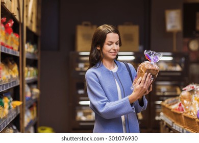 Sale, Shopping, Consumerism And People Concept - Happy Young Woman Choosing And Reading Label On Bread In Market