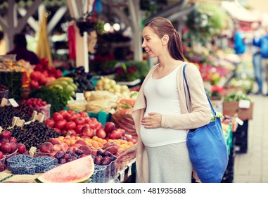 Sale, Shopping, Pregnancy And People Concept - Happy Pregnant Woman Choosing Food At Street Market