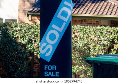 For Sale Sign Near The Residential Building House With 'SOLD' Sold Sticker On It. Auction Clearance Rate