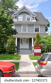 For Sale Sign On Lawn Of American Square Suburban Home Sidewalk