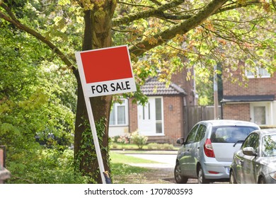 For Sale Sign Outside House On A Residential Street In Uk