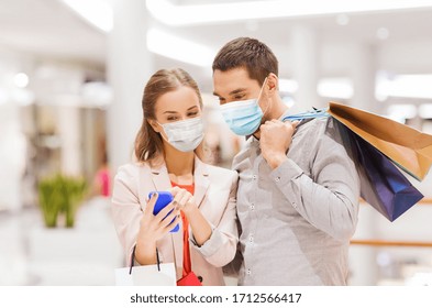 sale, technology and pandemic concept - happy young couple with shopping bags and smartphone wearing face protective medical mask for protection from virus disease in mall - Powered by Shutterstock