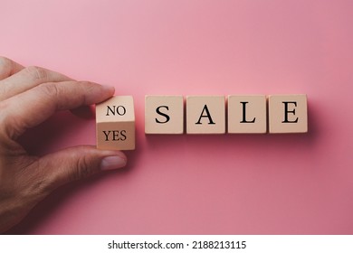 Sale word no to yes. Hand turns a dice and changes the word no to yes. On sale Cubes dice with Sale Yes or No on wooden background, pink color background. - Shutterstock ID 2188213115