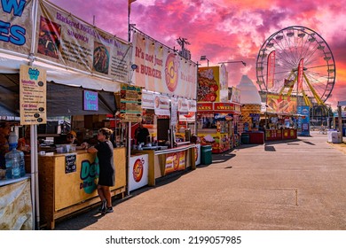 Salem, Oregon - September 2, 2022: Oregon Sate Fair Vendor Food Booths And Ferris Wheel With Beautiful Colorful Sunrise Sky.