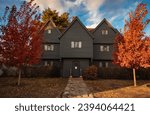 The Salem Witch House in Fall with bright red trees out front