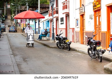 SALENTO, COLOMBIA - JULY 2021. Street Vendor Of Traditional Aborrajados Walking Along The Real Street In The Beautiful Small Town Of Salento