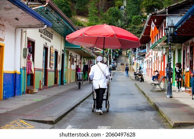 SALENTO, COLOMBIA - JULY 2021. Street Vendor Of Traditional Aborrajados Walking Along The Real Street In The Beautiful Small Town Of Salento