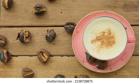 Salep and chestnuts in pink coffee mug on wooden table