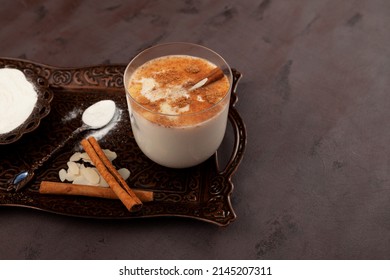 Salep - Turkish traditional hot drink with flour made from the tubers of orchid. Brown background, selective focus, copy space.