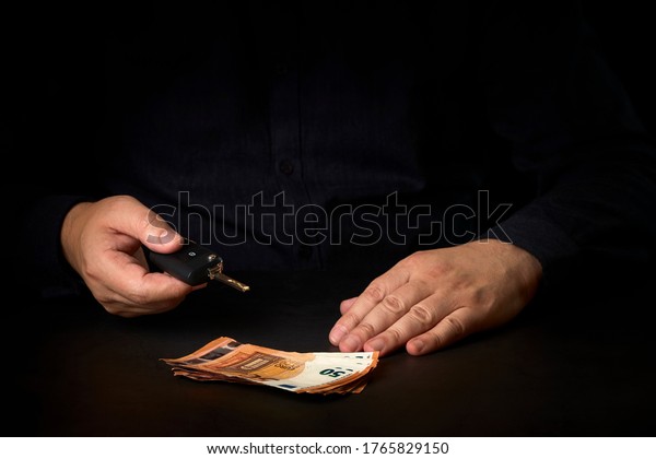 Sales agent with a car key and money on the\
table. Concept car sale, car\
renting