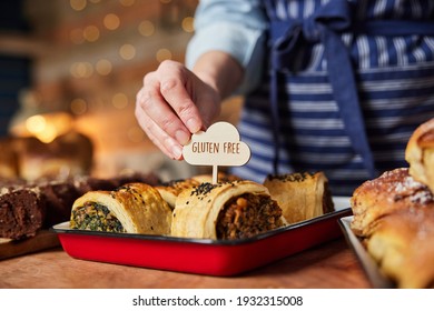 Sales Assistant In Bakery Putting Gluten Free Label Into Freshly Baked Savoury Roll - Shutterstock ID 1932315008