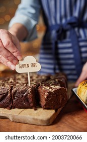 Sales Assistant In Bakery Putting Gluten Free Label Into Freshly Baked Chocolate Brownies - Shutterstock ID 2003720066