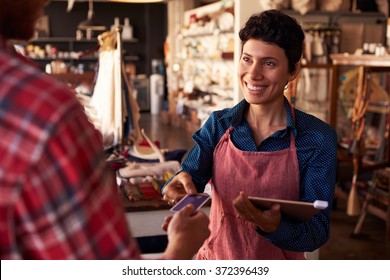 Sales Assistant With Credit Card Reader On Digital Tablet