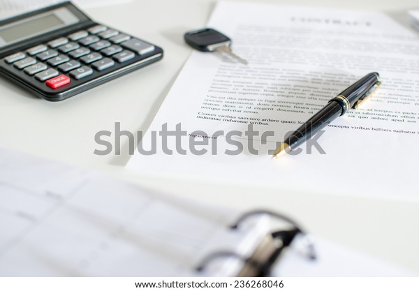 Sales\
contract, key, pen and calculator on a\
desk