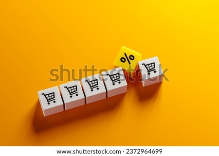 sales growth. shopping cart icon and percentage sign on cubes laid out on orange background. Increase higher sale volume and shopping trolley cart for online ecommerce business concept. copy space