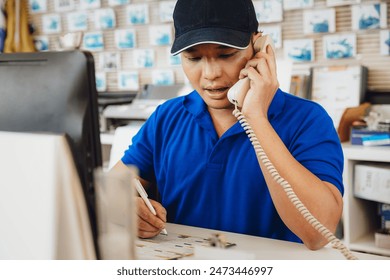 a sales man receiving phone call working at desk help support customer service in car auto garage workshop. - Powered by Shutterstock