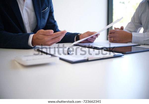 Sales manager giving advice application form document, considering mortgage loan offer for car and house insurance