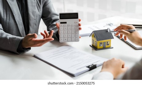 Sales Manager Or Real Estate Agent Show Calculator For Total Price For Buying A New House To Customer.