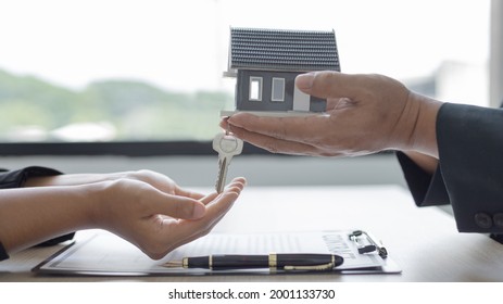 Sales Manager Or Salesperson Holds A Demo House And Has A Home Purchase Contract With Keys To Deliver To Interested Customers, Sales Service, Home Salesman With Insurance.