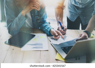 Sales Managers Working Modern Studio.Woman Showing Market Report Digital Tablet.Marketing Department Planning New Strategy.Researching Process Wood Table.Horizontal.Burred Background.Film Effect