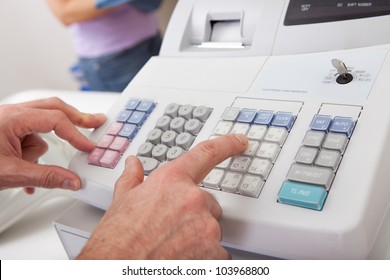 Sales Person Entering Amount On Cash Register In Retail Store