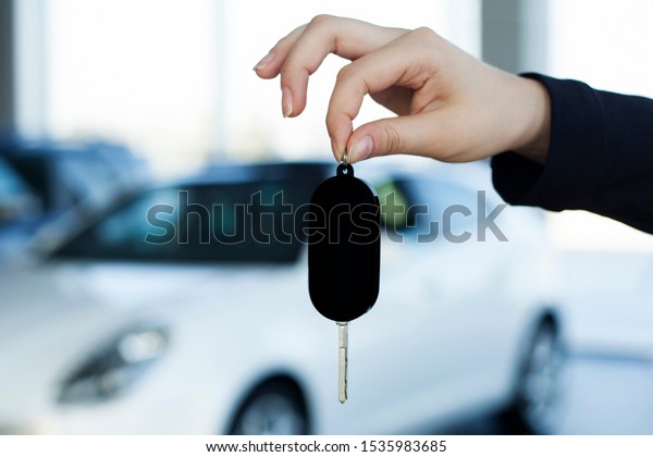 sales person giving car key\
in hand