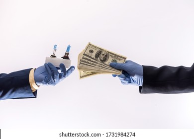 Sales In Quarantine Conditions Coronavirus Hands Holding Car Light Bulbs And Dollar Bills Isolated. Buying Car Concept