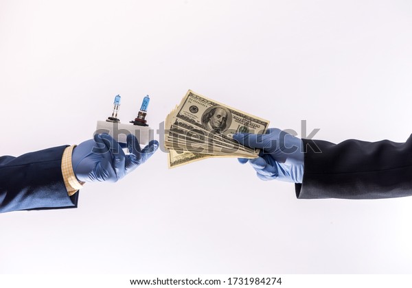 sales in\
quarantine conditions coronavirus hands holding car light bulbs and\
dollar bills isolated. Buying car\
concept