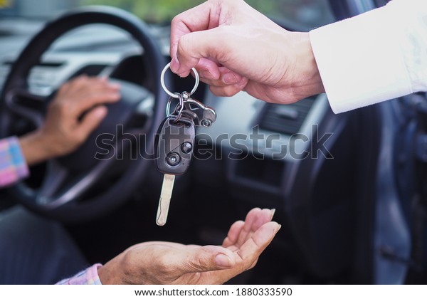 The sales\
representative is giving the car keys to the new owner in the car.\
Ideas for renting a car or buying a\
car.
