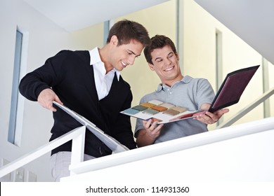 Sales Representative Showing Craftsman In Office A Sample Folder