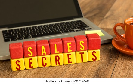 Sales Secrets Written On A Wooden Cube In A Office Desk