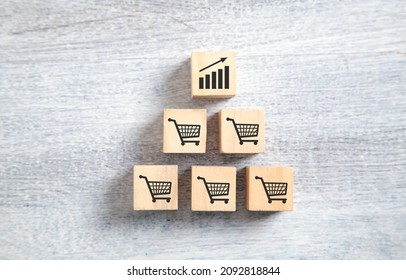 Sales Volume Increase. Shopping Carts And Growth Chart On Wooden Cubes