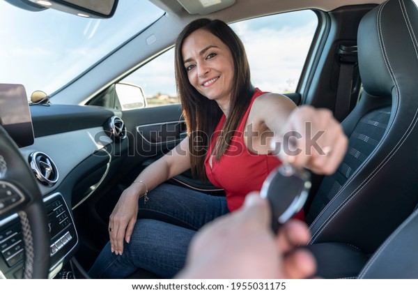sales woman inside the car passing the\
key to the customer to take a test drive - advertising for rent a\
car\
 - automotive industry concept - selective\
focus