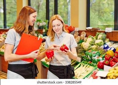 Salesclerk In Training Getting Help From Staff In A Supermarket